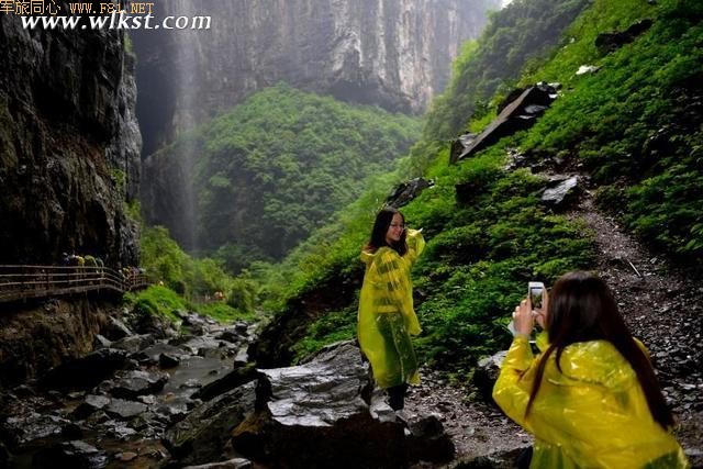 游览途中突然下起小雨,但达人们兴致依旧,图为身穿雨衣的达人在拍照。